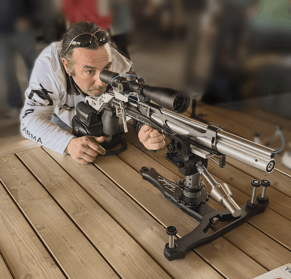 A shooter at the bench taking aim, the rifle resting on a LionWorks front rest at a match.